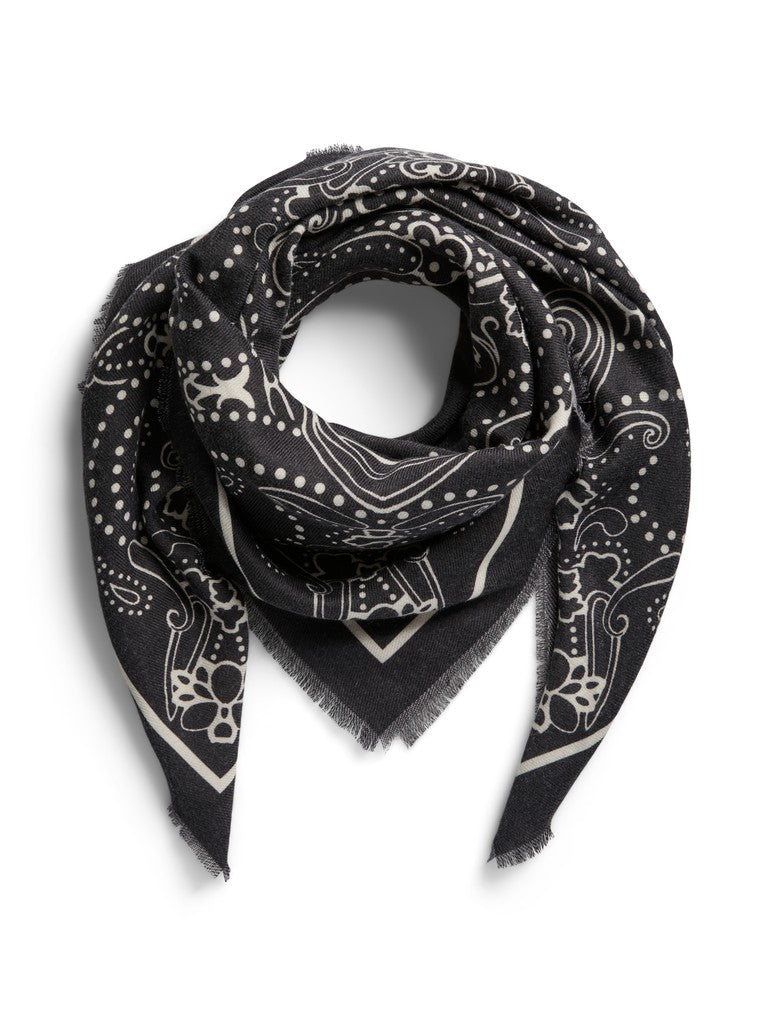 A black square scarf with a white paisley and skull pattern, styled in a loop with fringed edges on a white background.