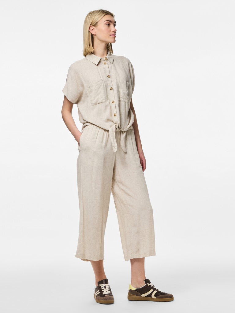 Woman wearing a beige outfit with a white background