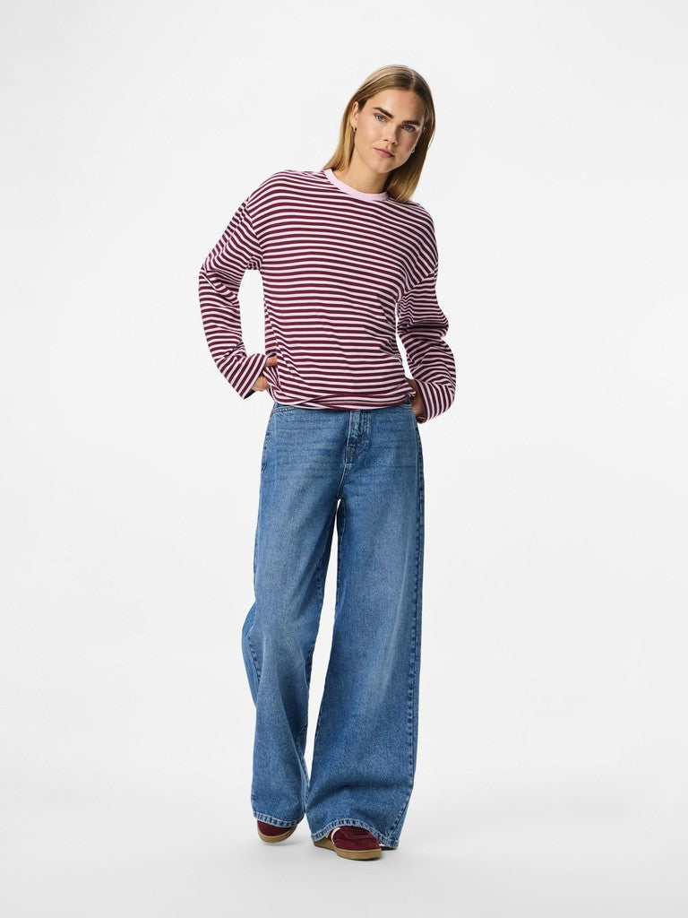 Person wearing a striped sweater and blue jeans on a white background