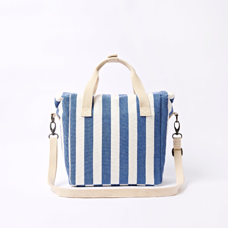 Roka Hampstead Blue and white striped lunch bag with beige handle and strap on a white background, rear view.