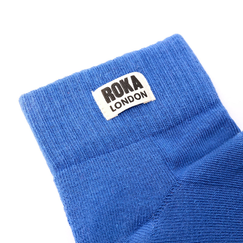Blue sock with Roka London label on a white background