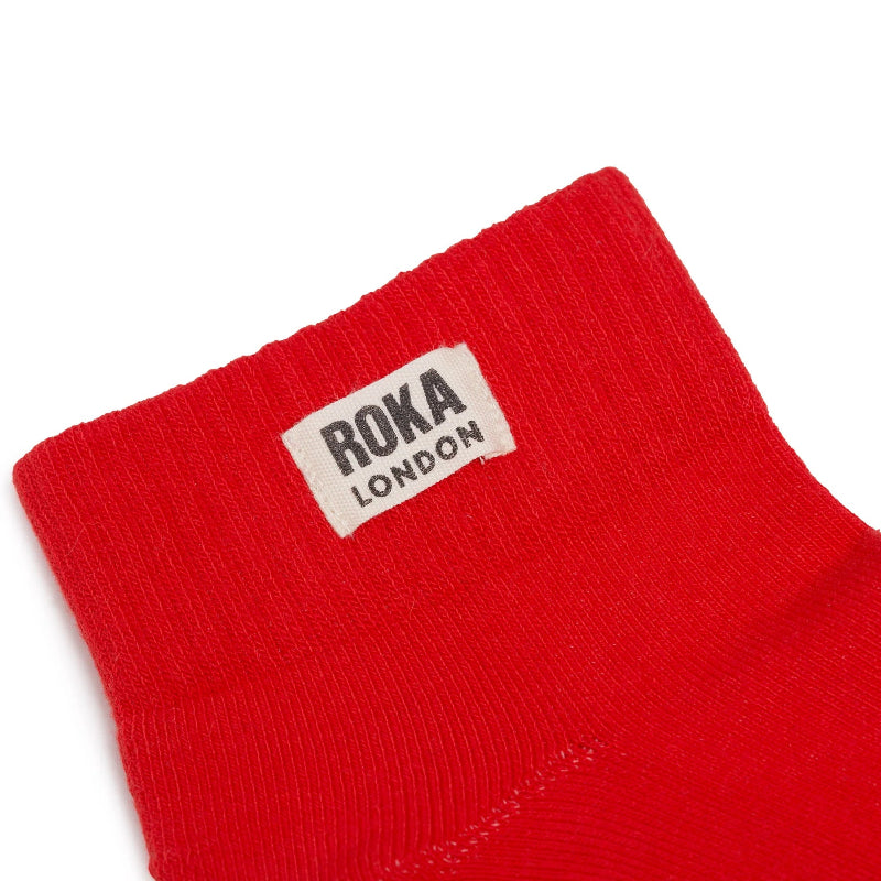 Red sock with Roka London label on a white background