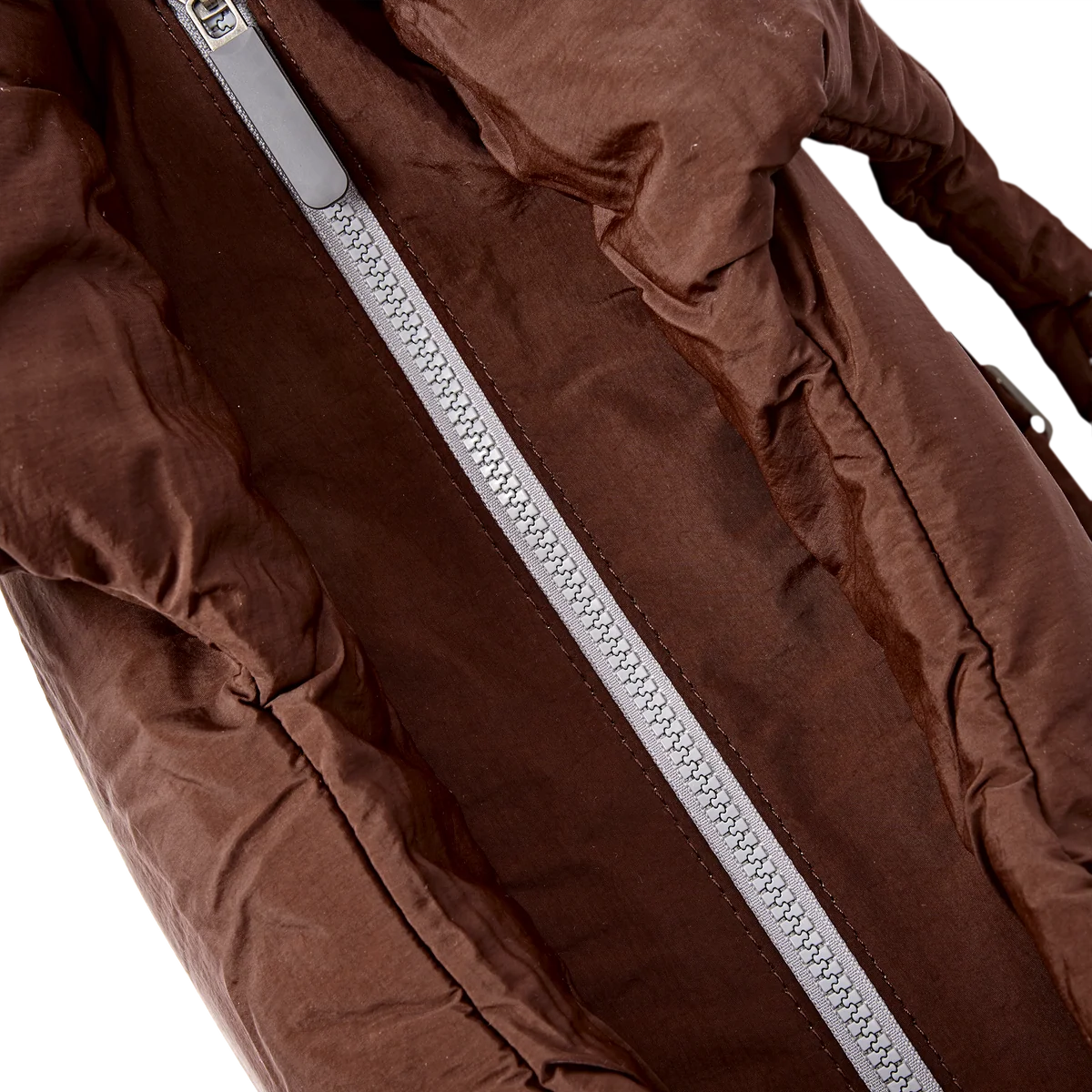 Close-up of a brown puffer jacket with a silver zipper, showing the textured fabric and zipper details against a white background.