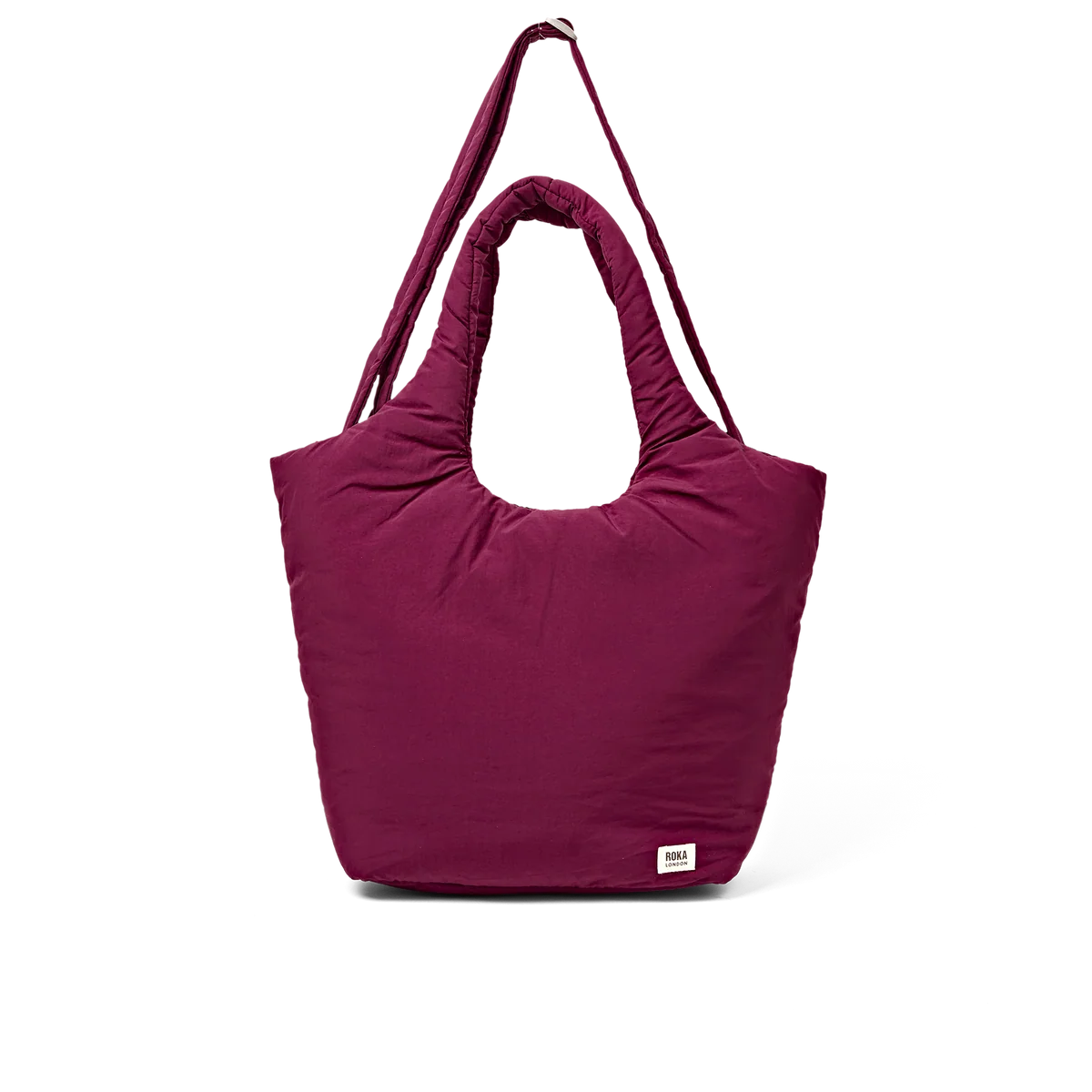 A deep magenta puffer tote bag with a single shoulder strap, shown against a plain white background. A small white rectangular brand tag is visible on the lower right corner of the bag.