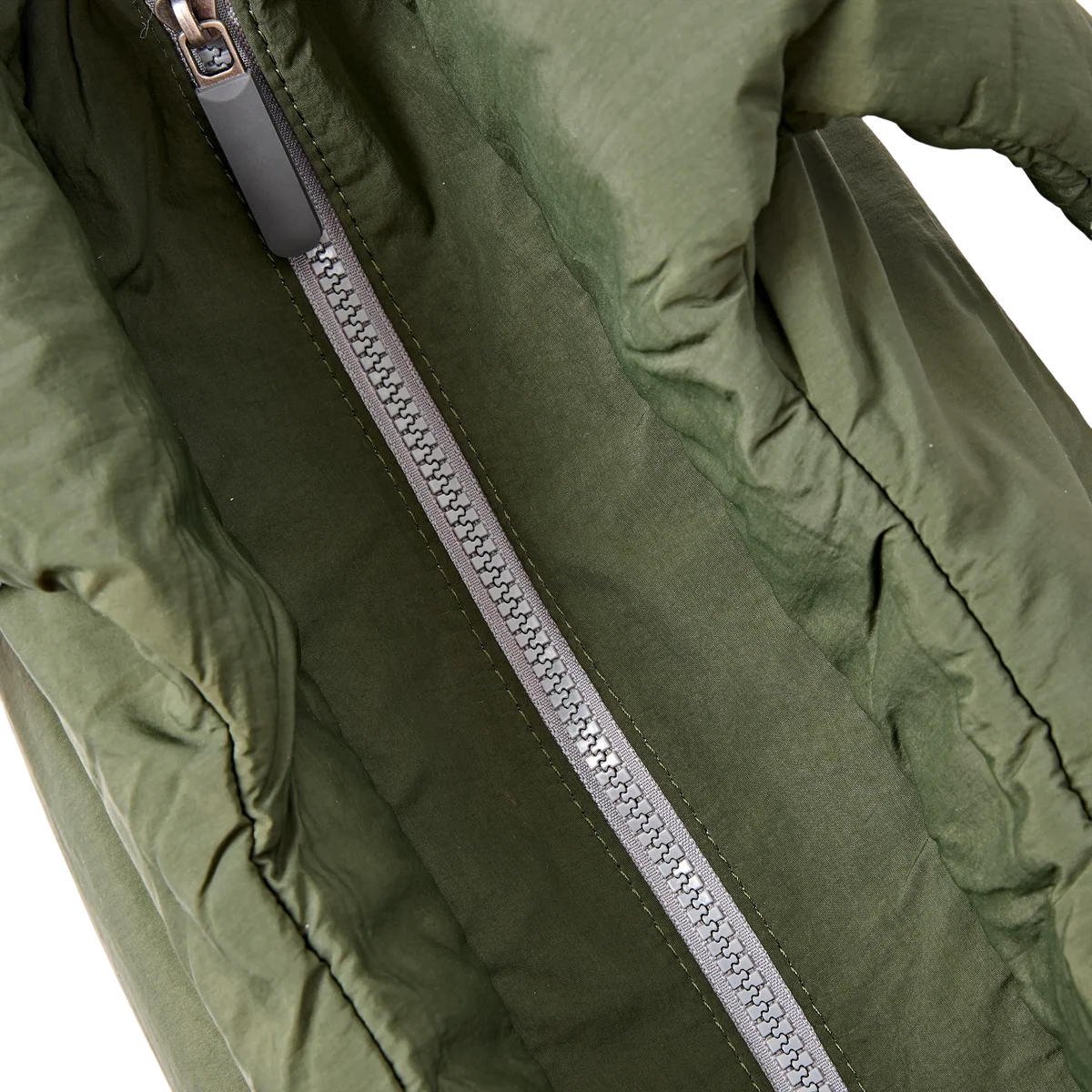 Close-up of an olive green puffer jacket with a silver zipper and gray pull tab, shown against a white background.