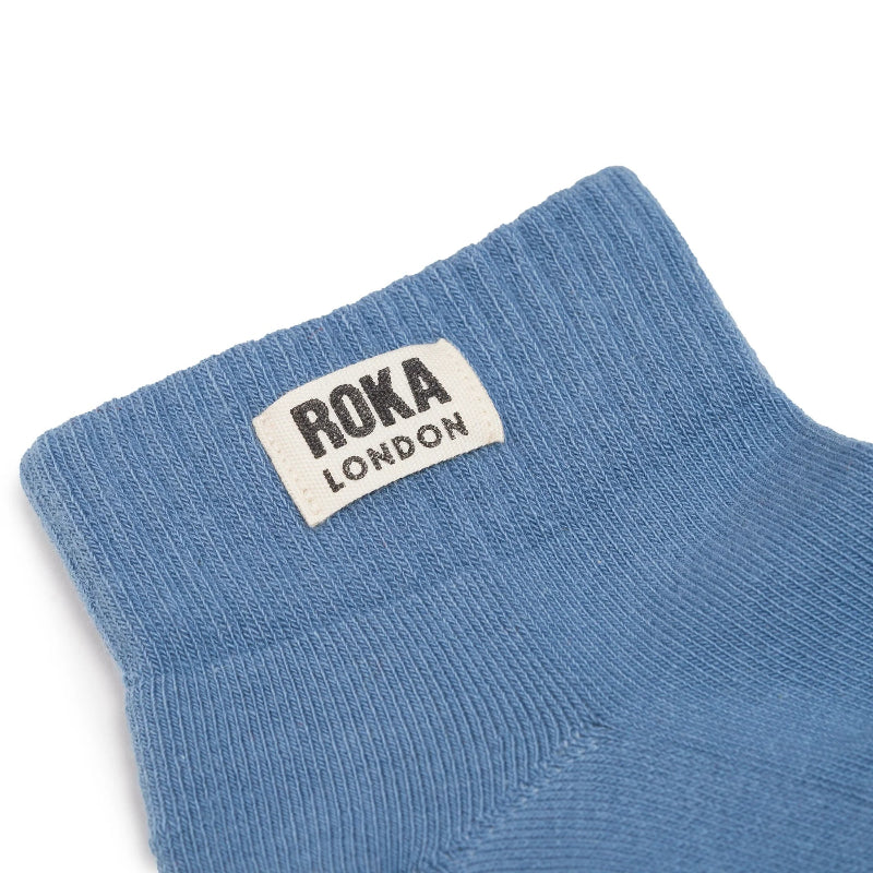 Blue sock with Roka London label on a white background