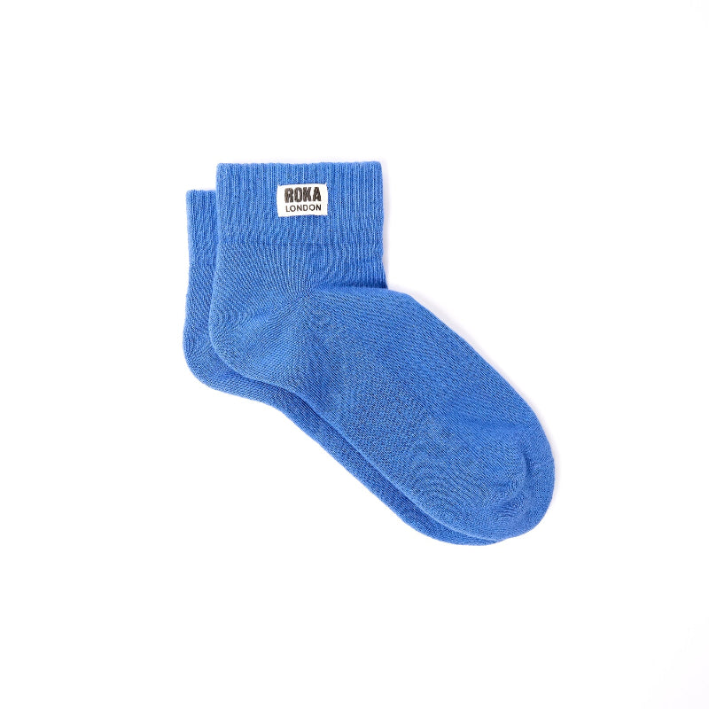 Blue sock with 'Roka London' label on a white background