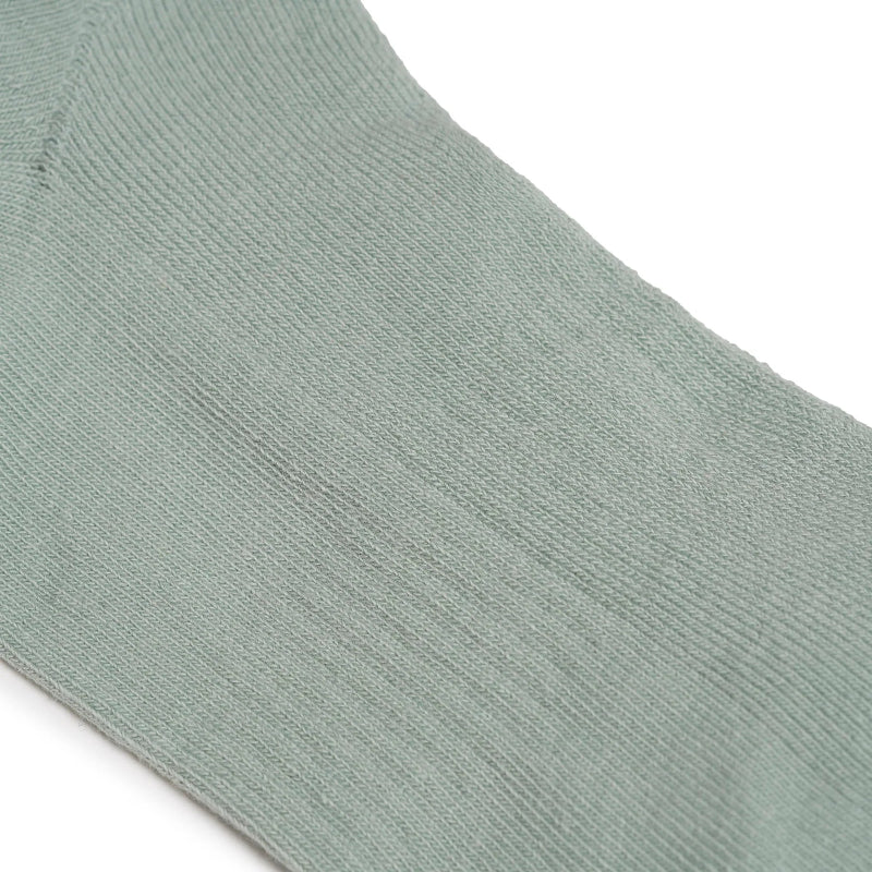 Close-up of a light green sock on a white background