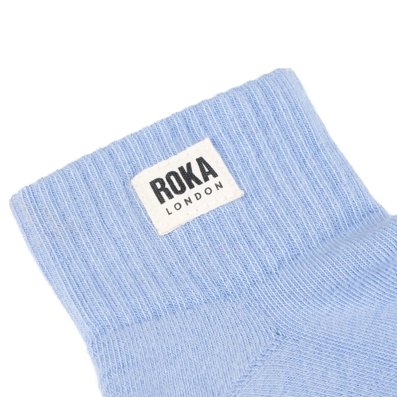Light blue socks with a Roka London label on a white background