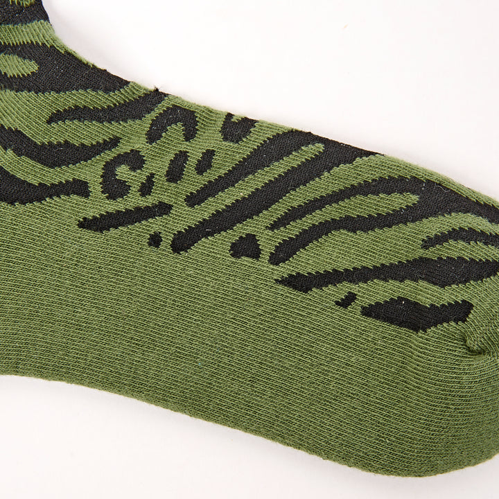 Green sock with black tiger stripe pattern on a white background