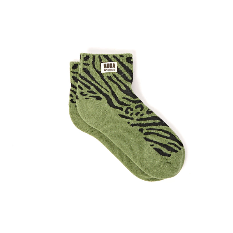 Green socks with black zebra pattern on a white background