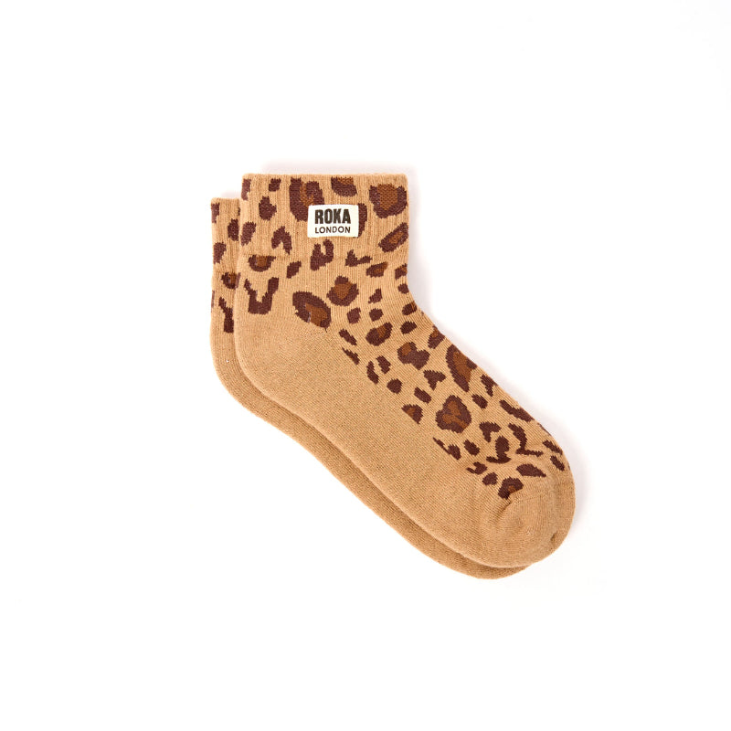 Pair of tan socks with brown leopard print pattern on a white background