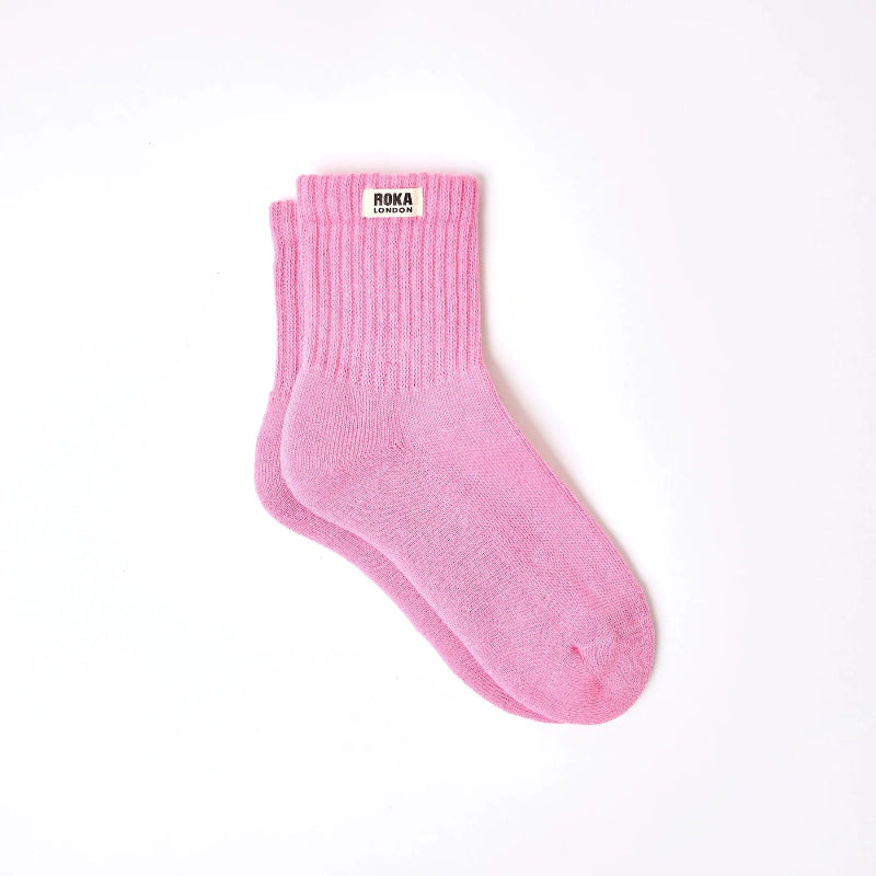Pink sock with a brand label on a white background