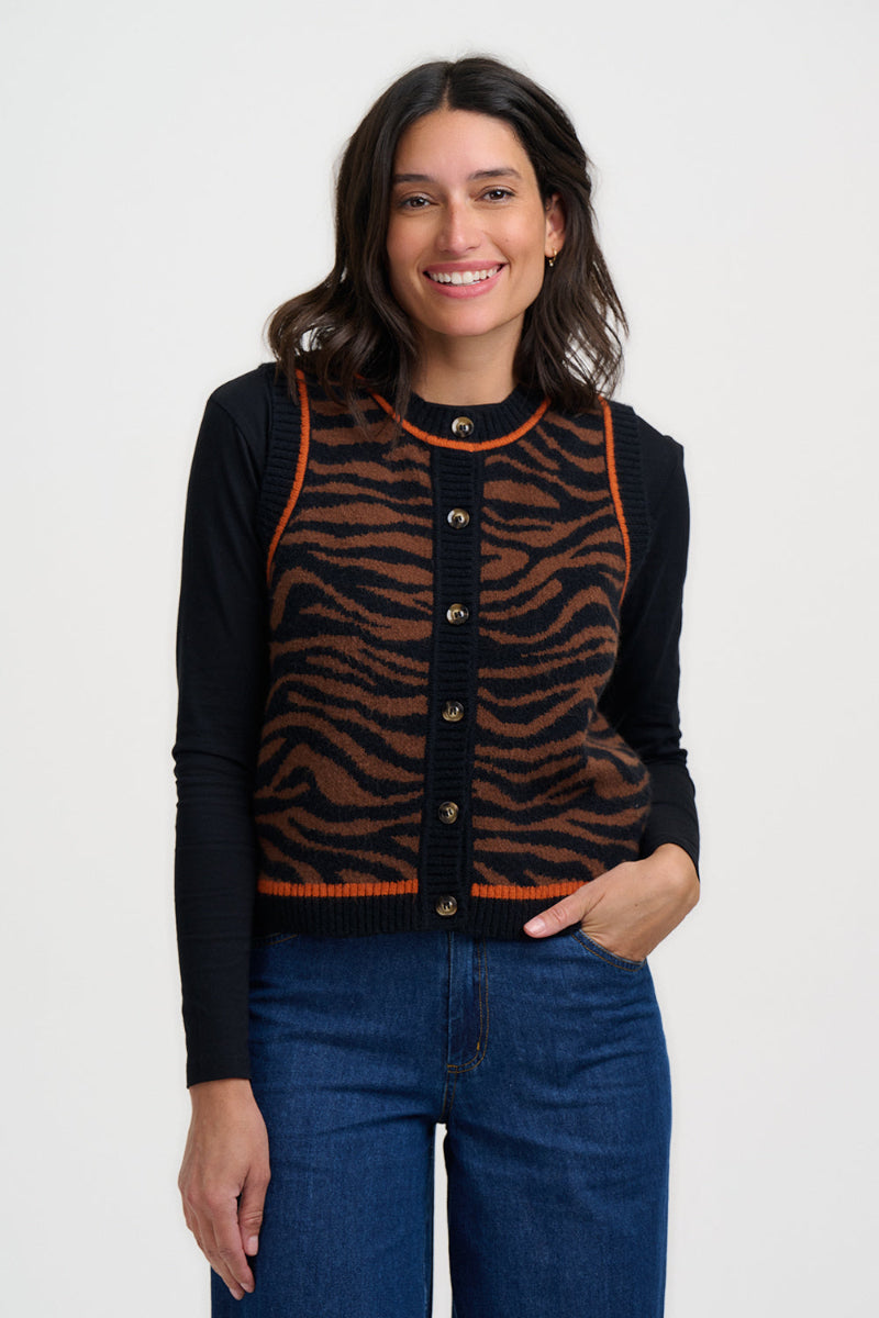 Woman wearing a black cardigan with a tiger stripe pattern on a white background