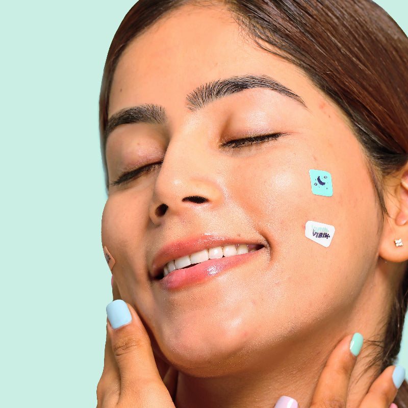 Woman with patches on her face against a teal background