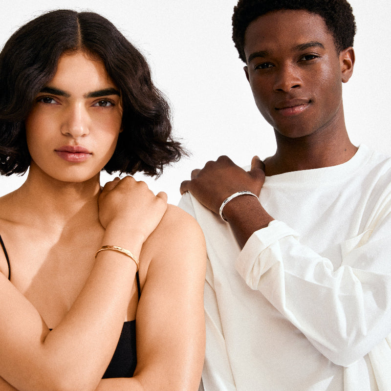 Two people standing close together with a plain background