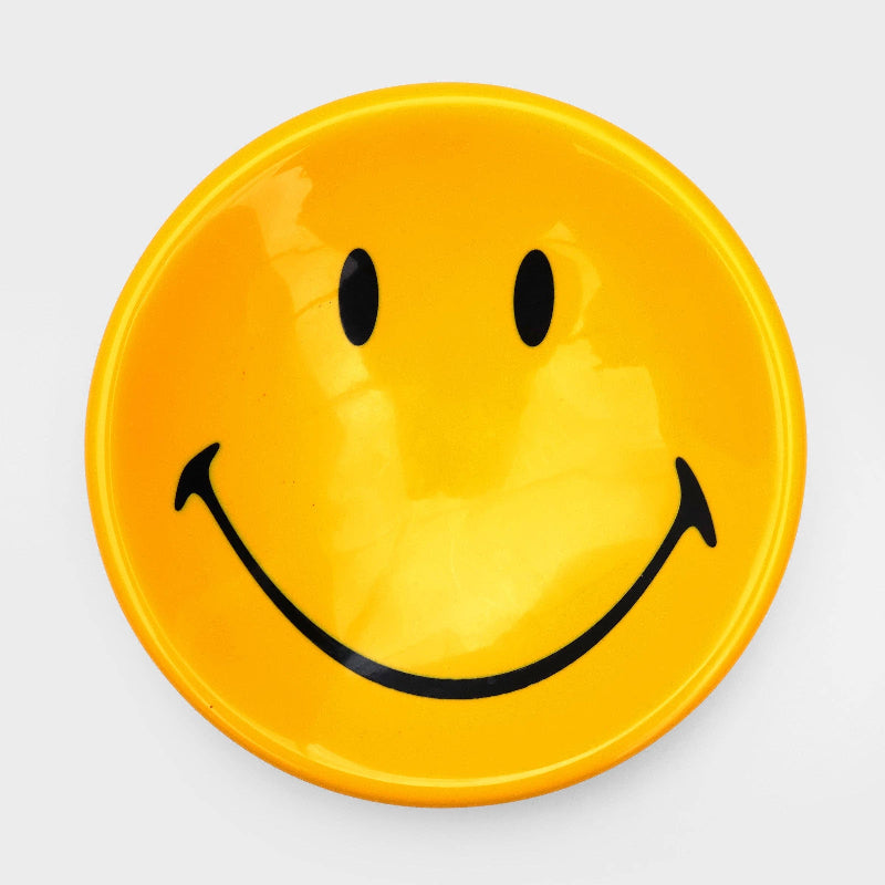 Yellow plate with a smiley face design on a white background