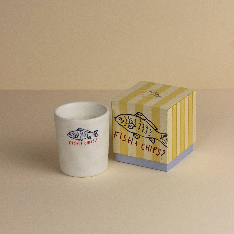 White mug with 'Fish & Chips?' design next to a matching striped box on a beige background
