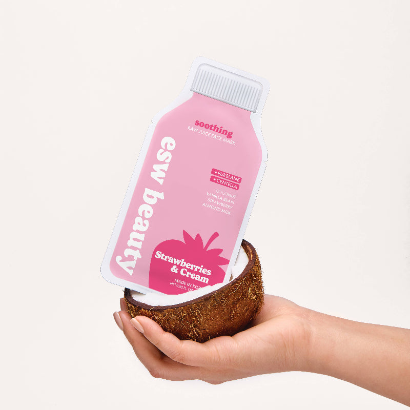 Hand holding a pink ESW Beauty product in a coconut against a white background