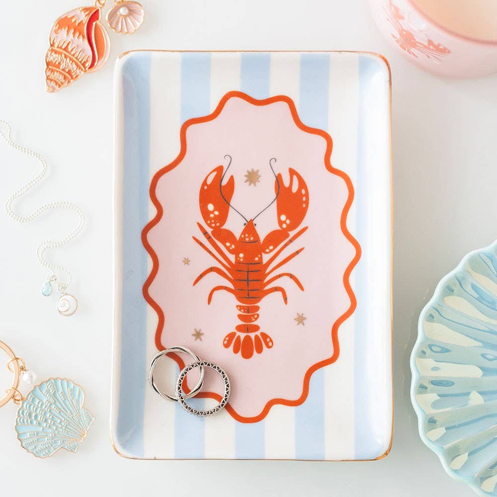 Tray with a lobster design on a striped background, surrounded by decorative items.