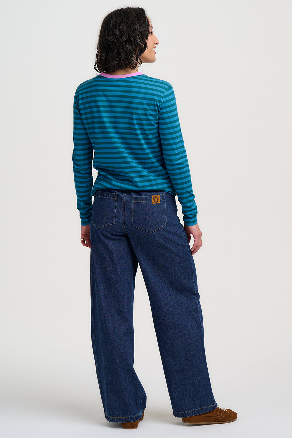 Person wearing a Sugarhill Brighton Brunswick Lucky Cat Jersey Top and blue jeans on a white background