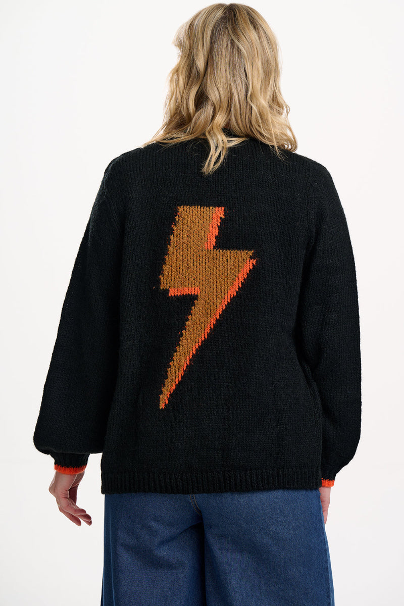 Person wearing a black sweater with a brown lightning bolt design on the back.