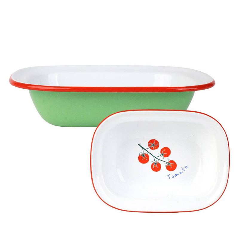 Green and red enamelware dish with a white dish featuring a tomato design on a white background