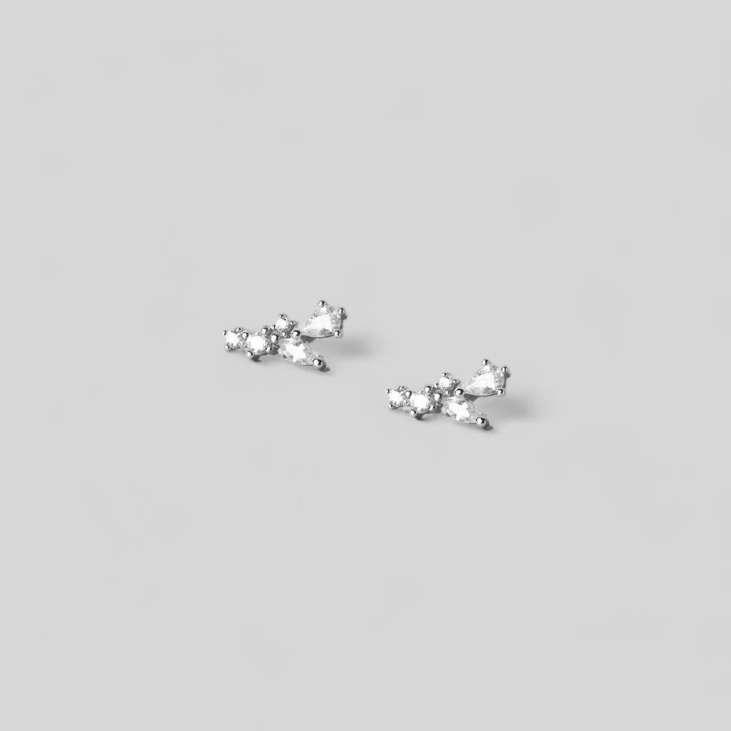 Pair of silver cross-shaped earrings on a light gray background