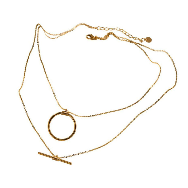 Gold necklace with circular pendant on a white background