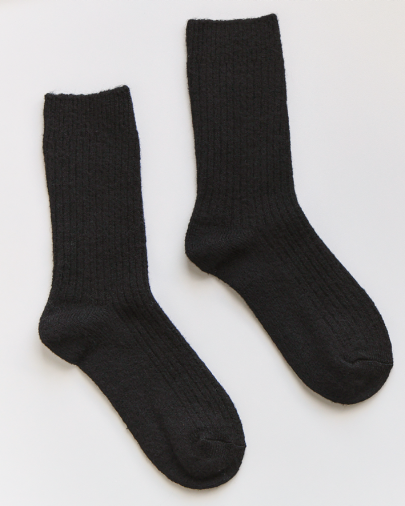 Pair of black socks on a white background with a label.