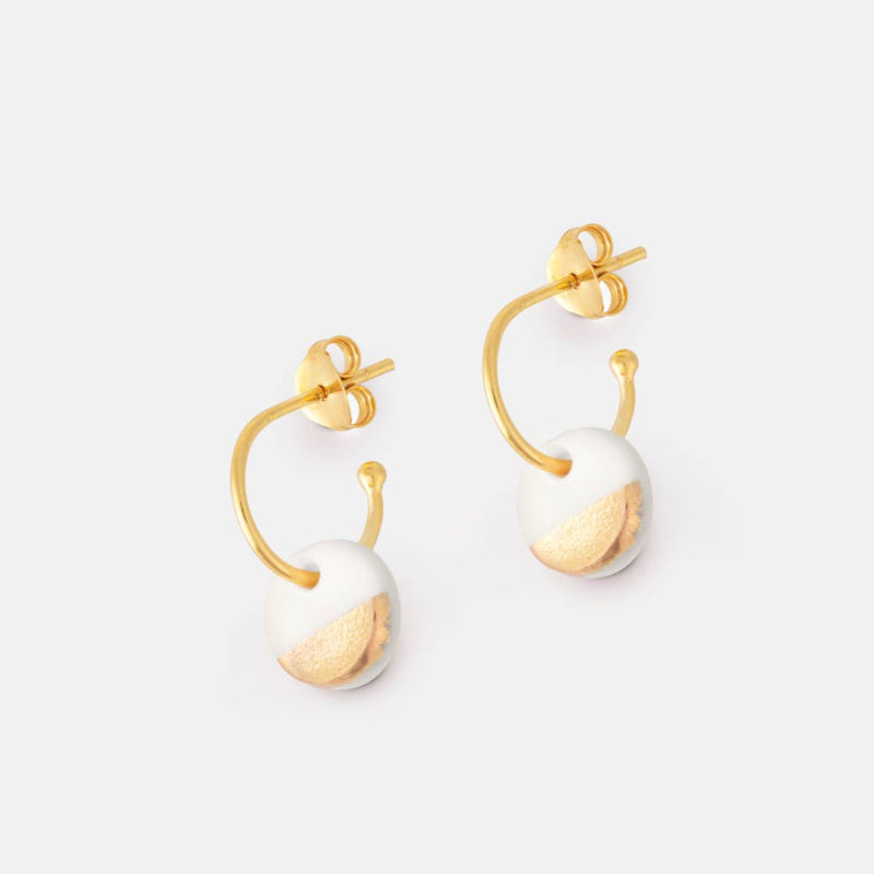 Gold and pearl earrings on a white background
