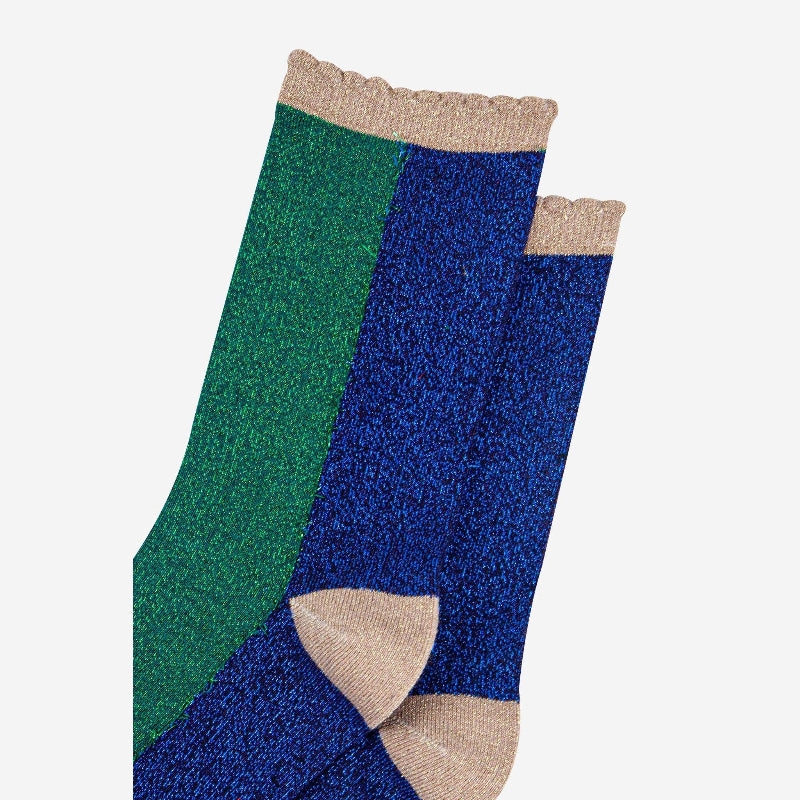 Pair of green and blue socks with beige accents on a white background