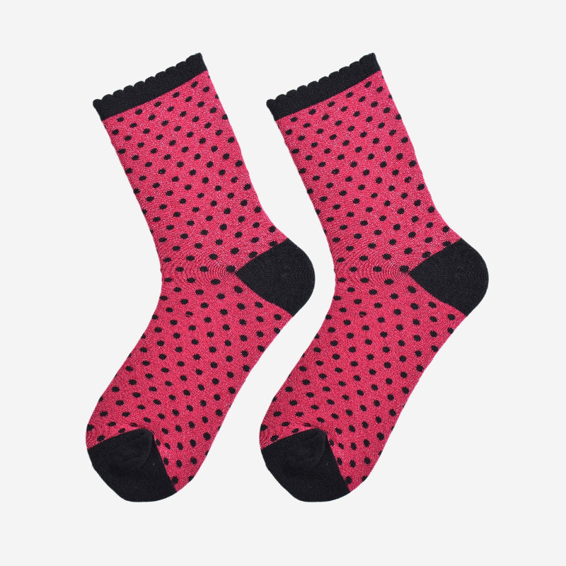 Pink socks with black polka dots on a white background