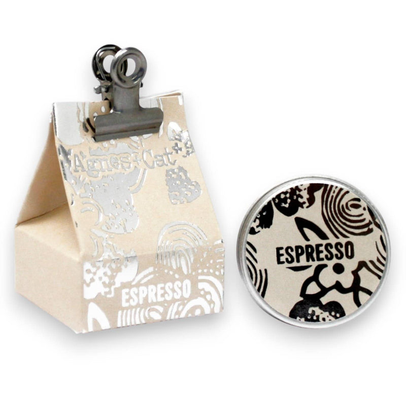 Small beige box with espresso design, clip, and round espresso-themed item on a white background