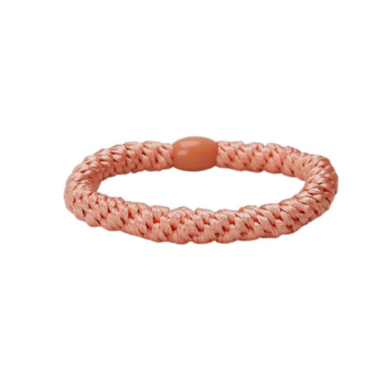 Pink woven bracelet on a white background