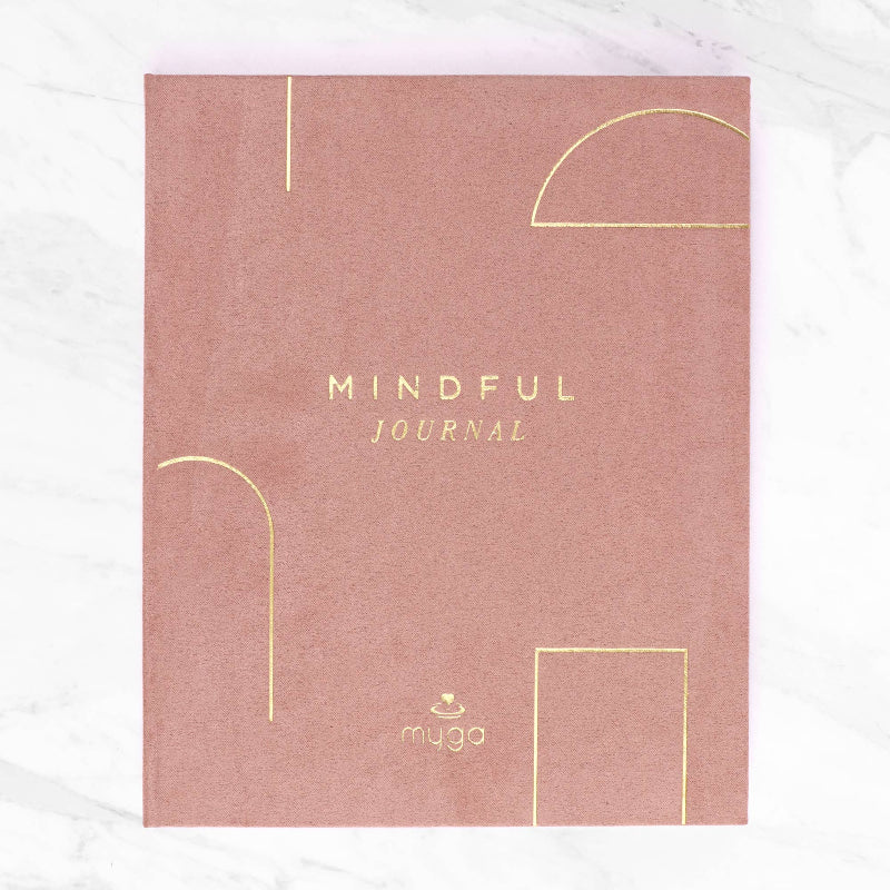 Pink mindful journal with gold text on a white background