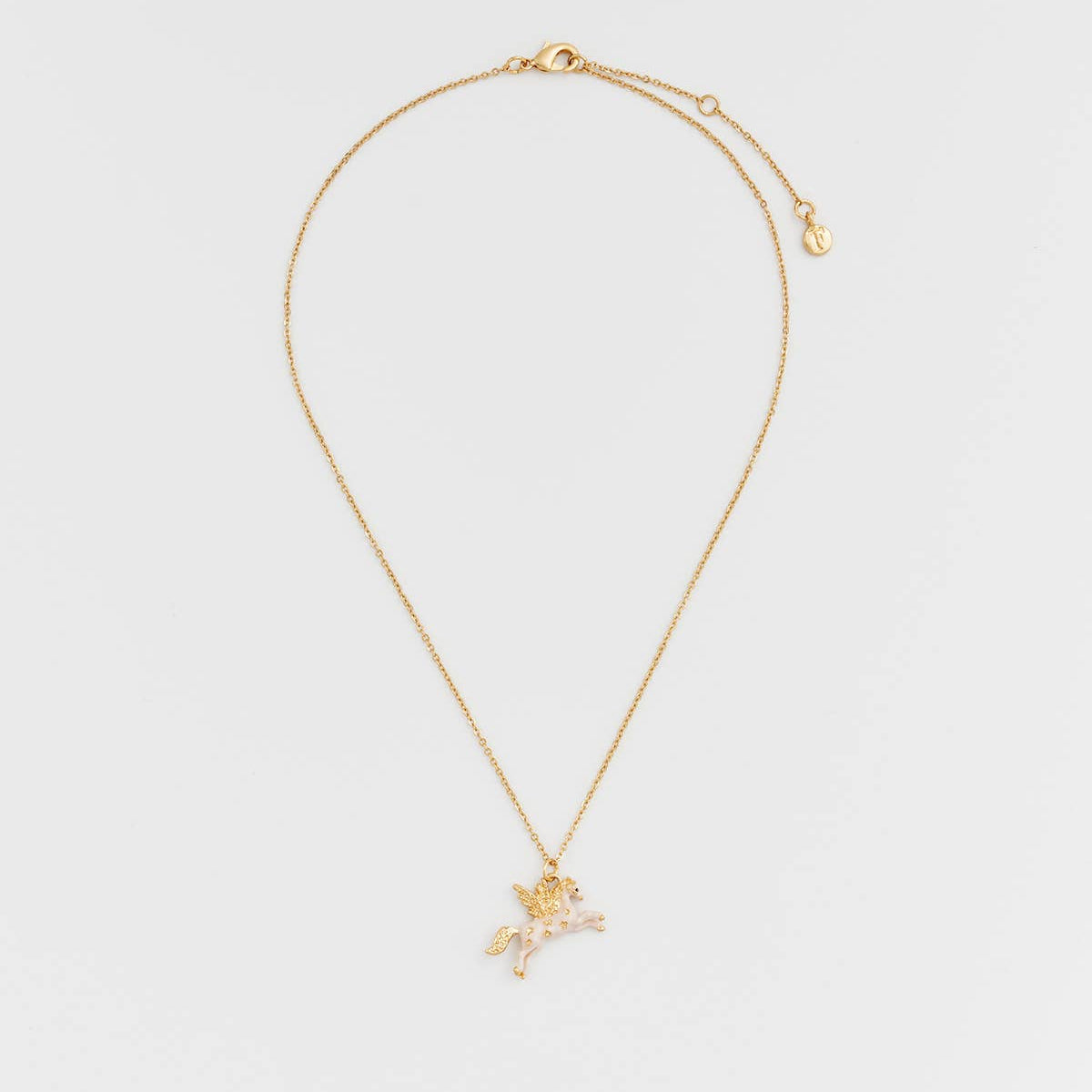 A delicate gold chain necklace featuring a small winged cherub pendant adorned with clear crystals, displayed against a clean, light gray background.