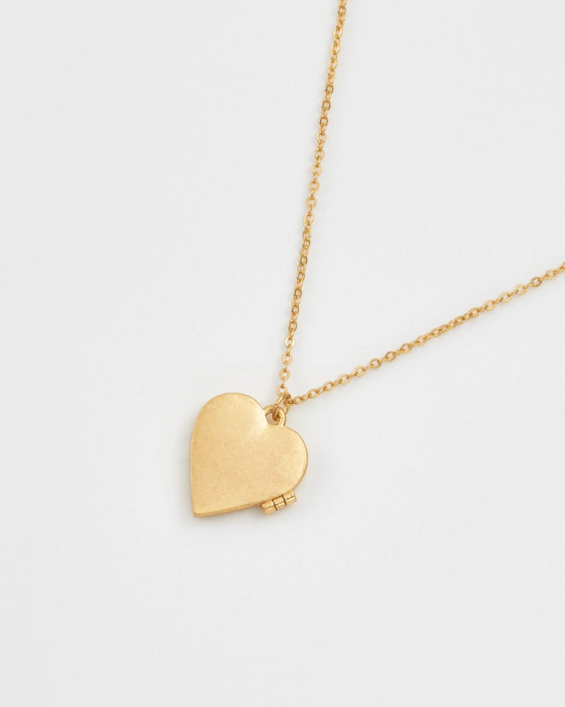Fable England Gold heart-shaped locket necklace on a white background