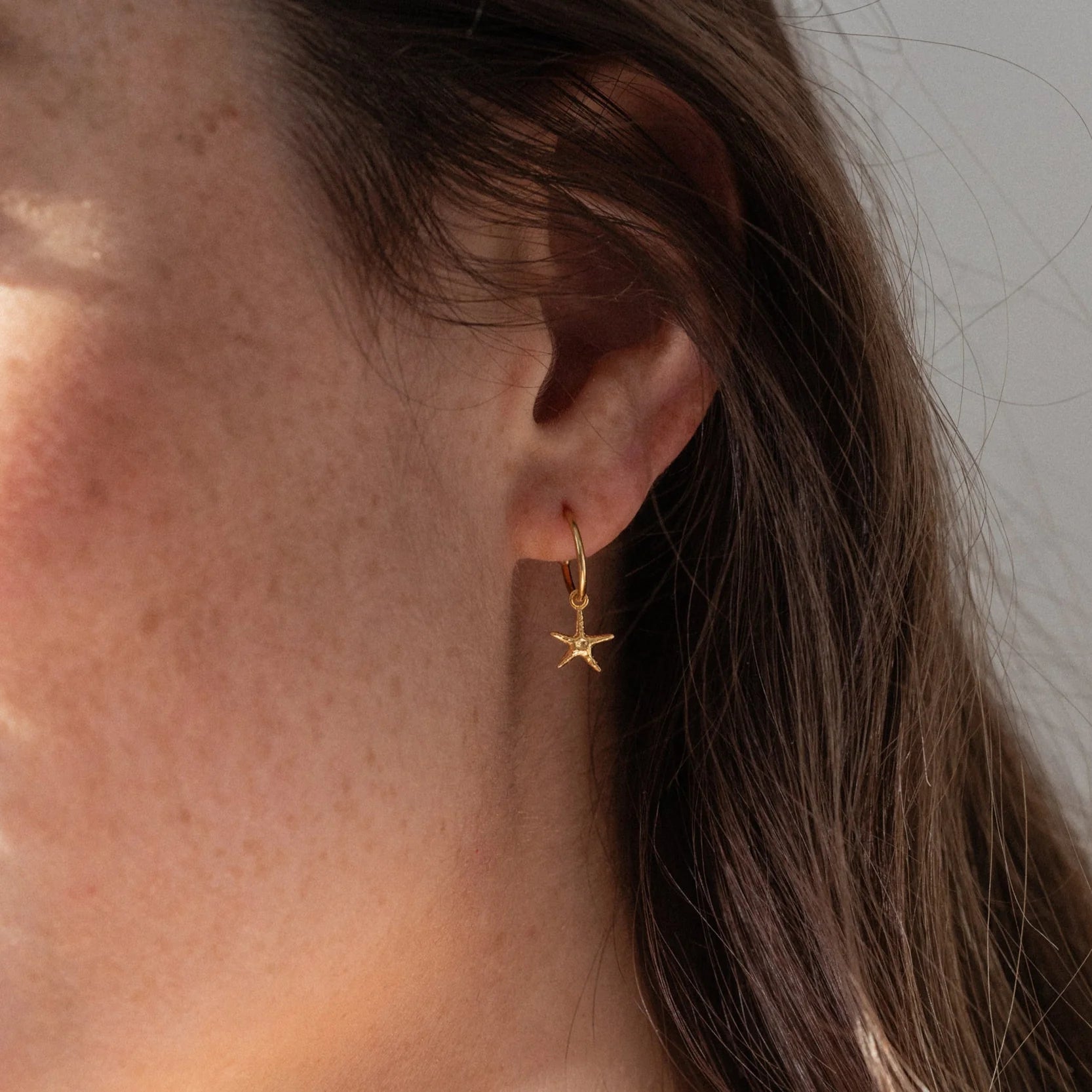1 & 8 Gold Starfish Earrings on model