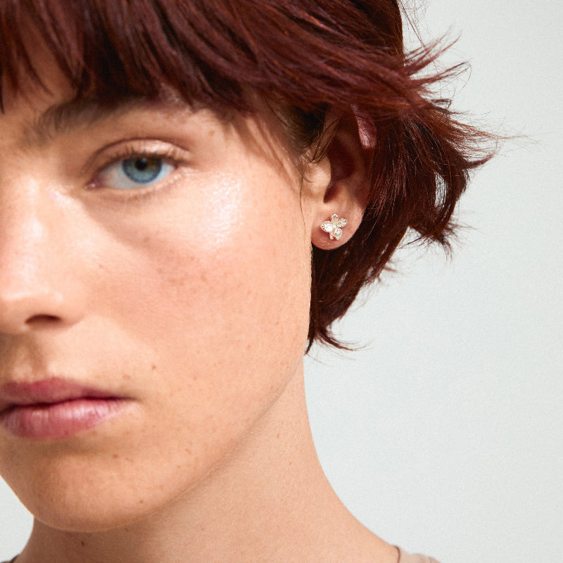 Close-up of a person wearing a Pilgrim Charmaine Earrings silver-plated with a plain background