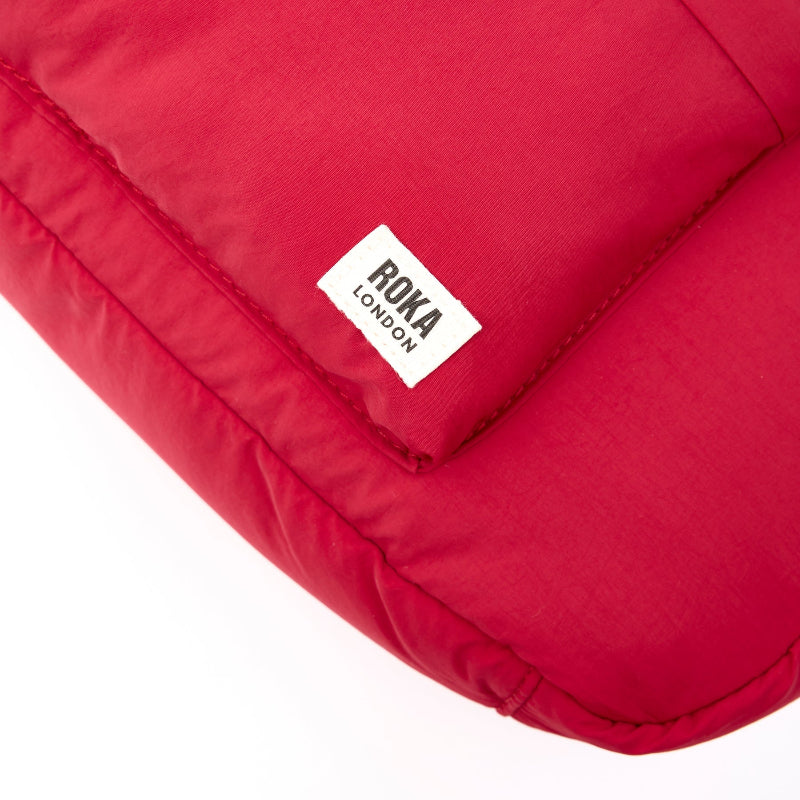 Red bag with a Roka London label on a white background