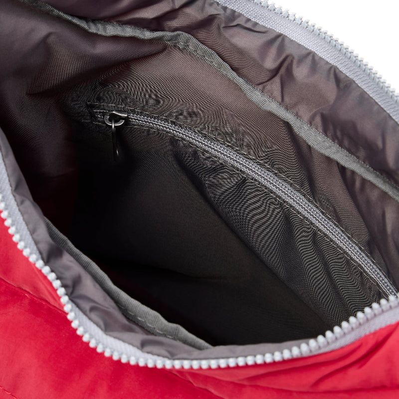 Close-up of a red bag with a zipper, showing the interior.
