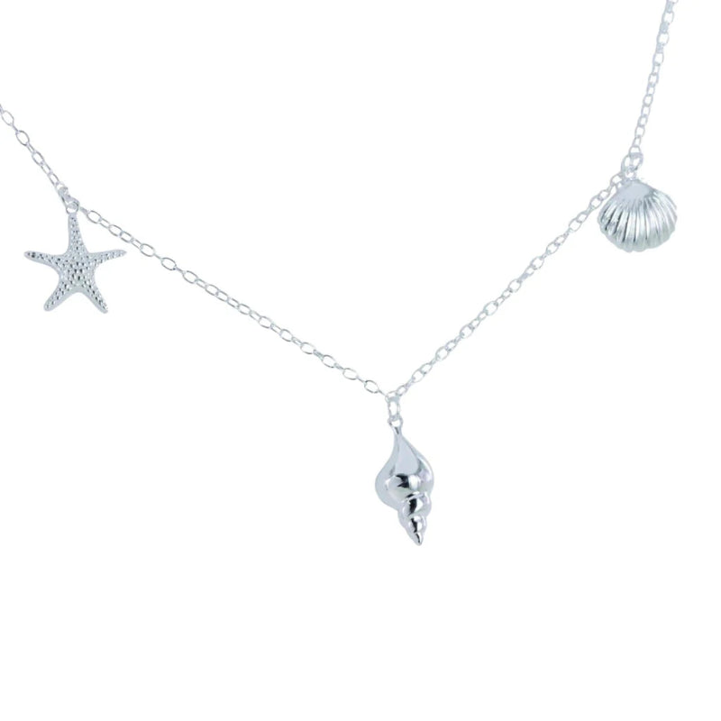 Silver necklace with starfish, shell, and wave pendant on a white background