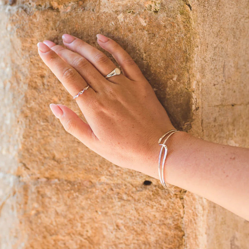 Hand with multiple rings on a stone surface