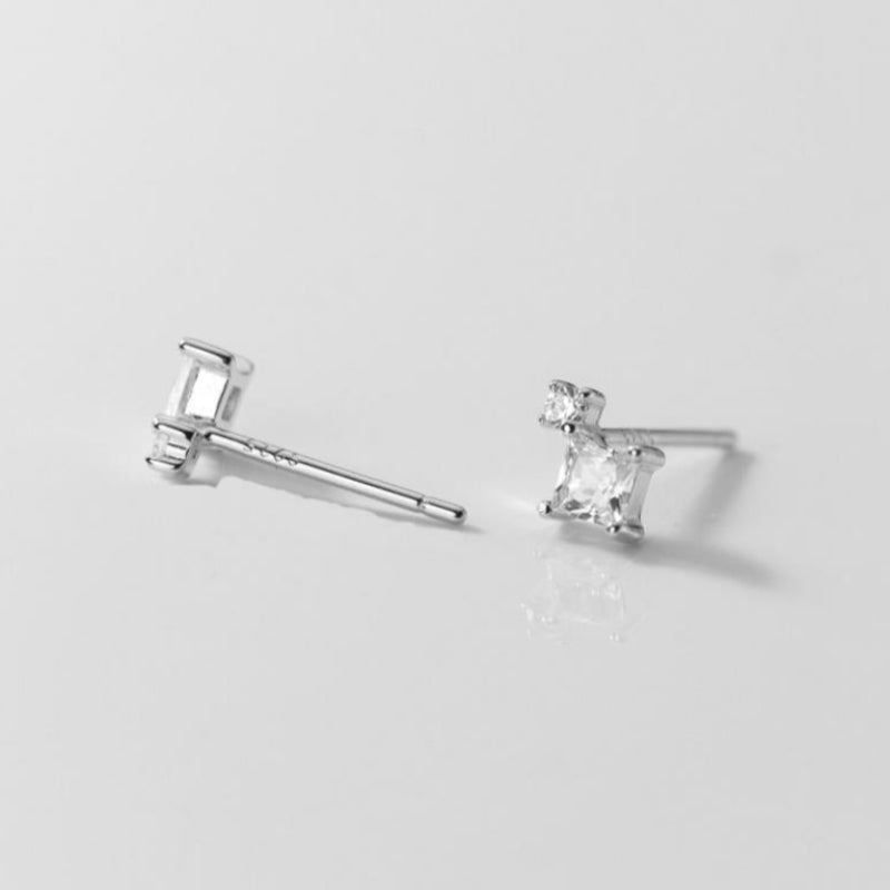 Pair of silver stud earrings on a light gray background