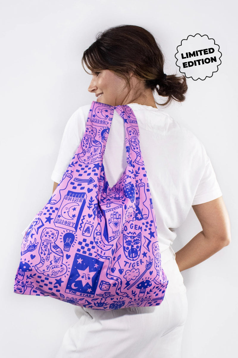 Woman carrying a pink and blue patterned bag with 'Limited Edition' text on a white background