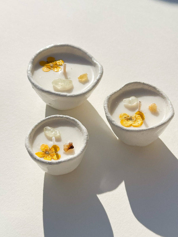 Three small ceramic bowls with white contents and decorative flowers on a light background