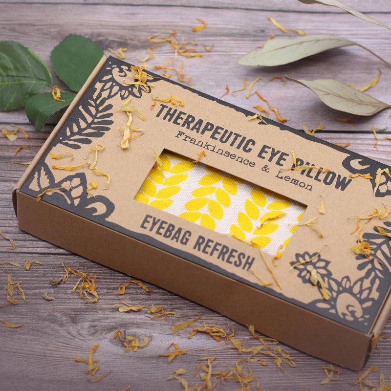 Therapeutic eye pillow packaging with yellow leaves on a wooden surface