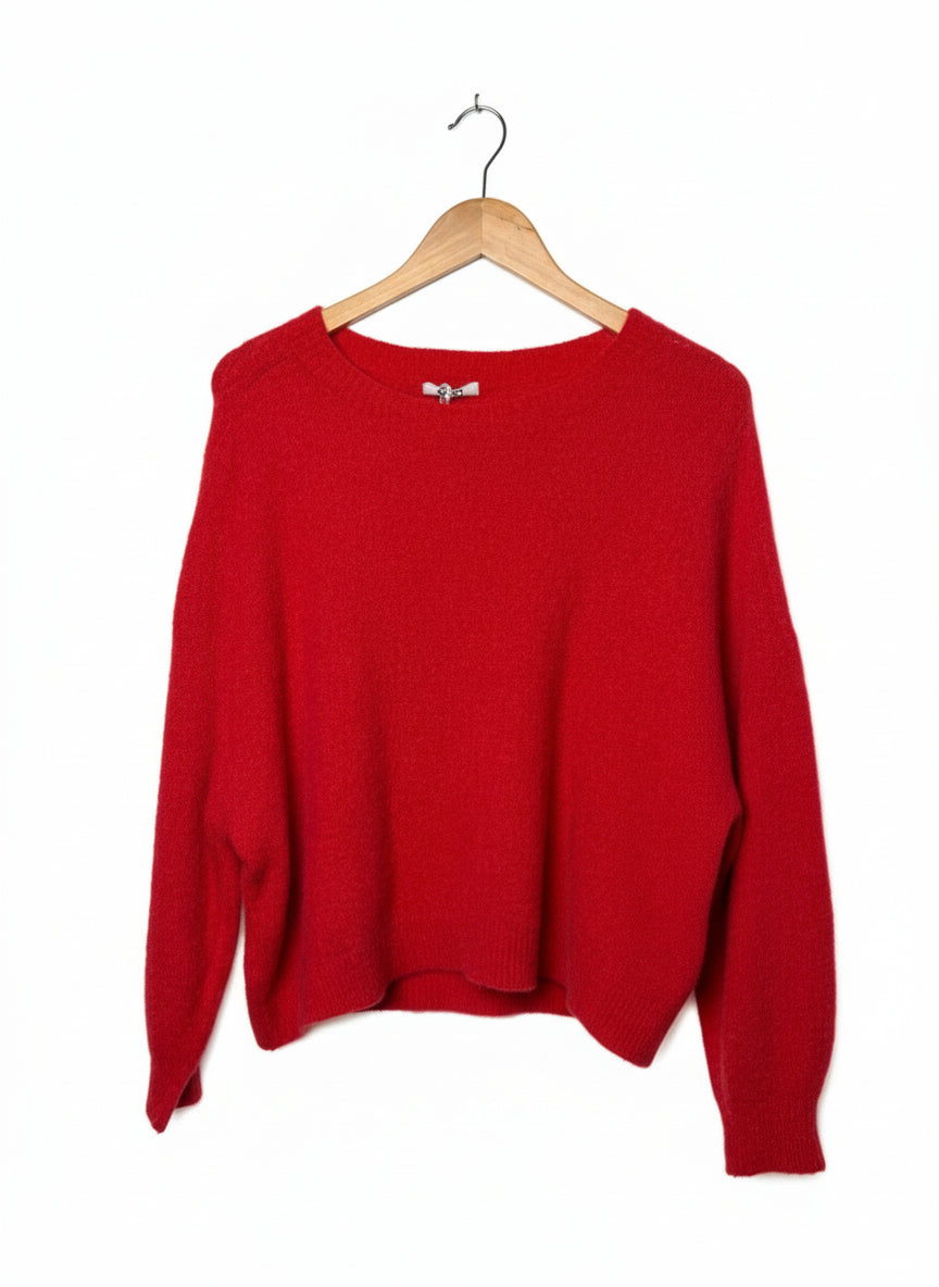 Red sweater on a wooden hanger against a plain background