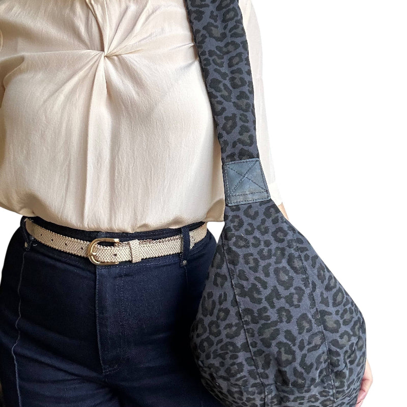 Person wearing a blue leopard print bag with a plain background